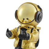 Alt text: Close-up of a golden astronaut sculpture wearing a gold helmet and jacket, with black gloves reaching out. The sculpture is detailed with a reflective helmet and intricate costume design.