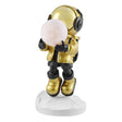 Full view of a golden astronaut sculpture holding a lighted moon. The astronaut is wearing a gold helmet, jacket, and boots, with black gloves and pants, standing on a white, faceted base.