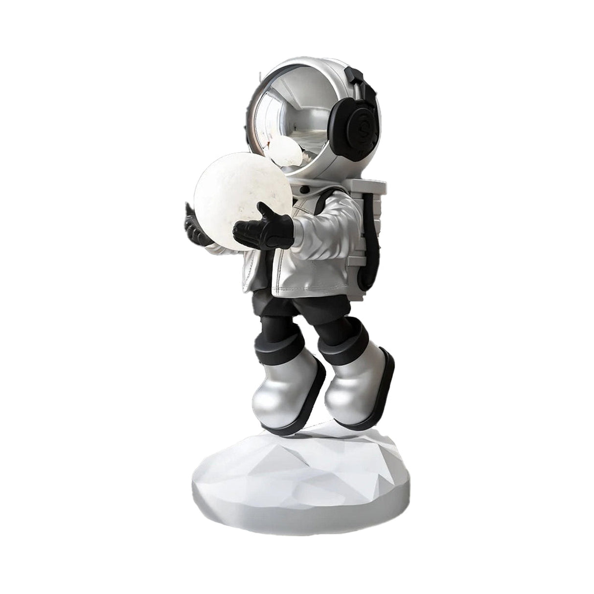 Full view of a silver astronaut sculpture holding a lighted moon, isolated on a white background. The astronaut is wearing a silver helmet, jacket, and boots, with black gloves and pants, standing on a white, faceted base.