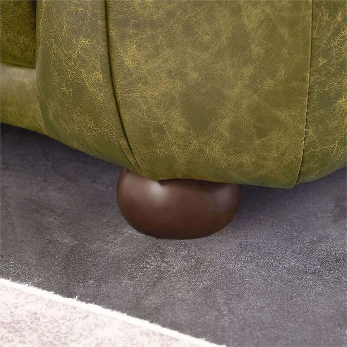 Close-up of the Ashcroft Marlon Luxury Italian Leather Sofa's rounded wooden legs, emphasizing its sturdy and stylish support.